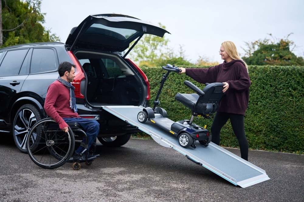Wheelchair user approaching an accessible entrance using an aluminium access ramp